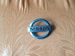 Эмблема крышки багажника (фирменный значок) на Nissan Maxima QX 