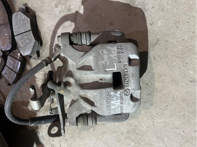 Тормозной суппорт задний левый B4Y72699ZD MAZDA