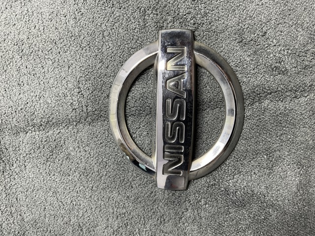 Фирменный значек на багажник 90890AU400 NISSAN