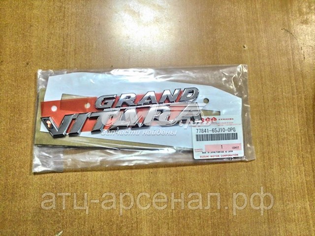 7784165J100PG Suzuki emblema de tampa de porta-malas (emblema de firma)